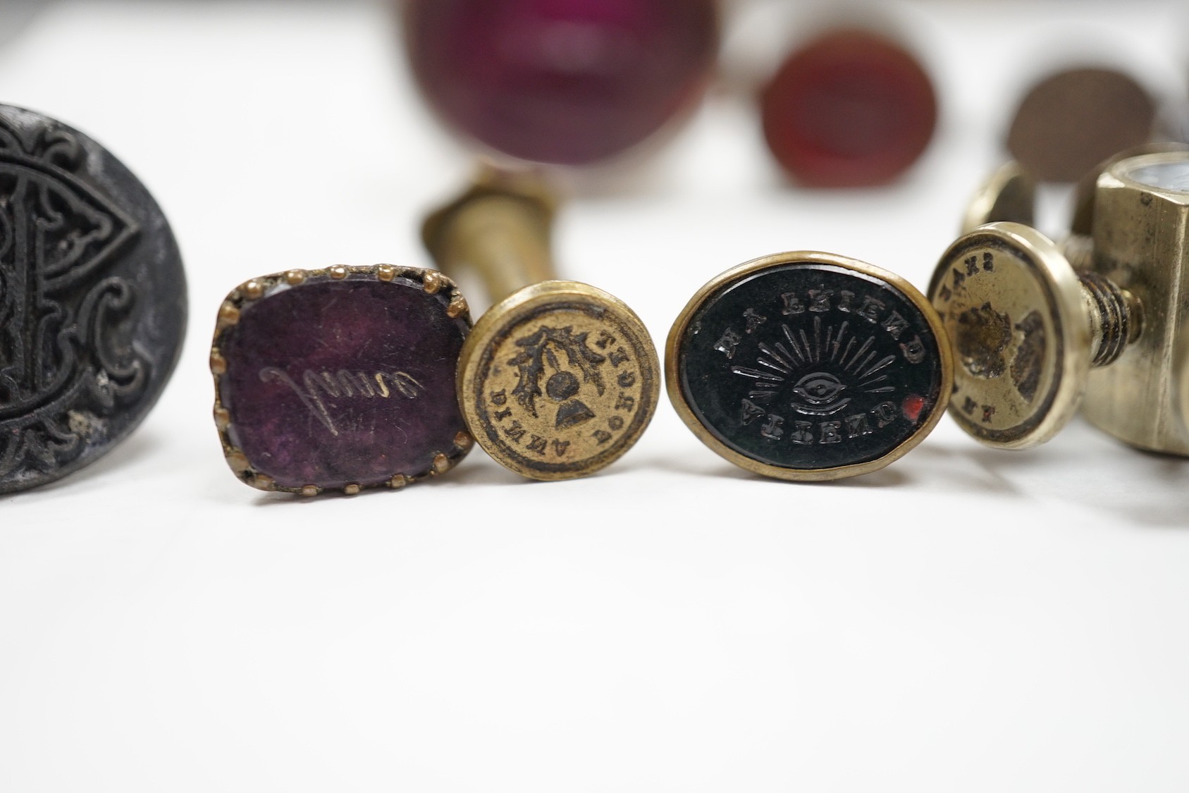 A group of twenty-five steel, gilt metal or nickel fob or desk seals, mostly 19th-century, including a steel swivel seal, a seal with boxwood finial modelled as a hand holding a ball and a nickel multi seal